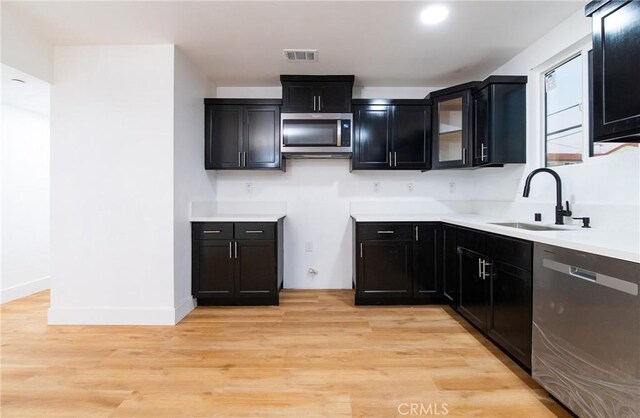 kitchen with light hardwood / wood-style flooring, stainless steel appliances, and sink