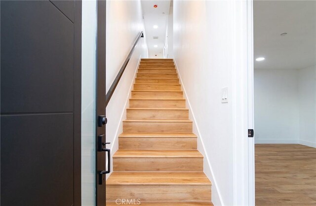 stairs featuring hardwood / wood-style flooring