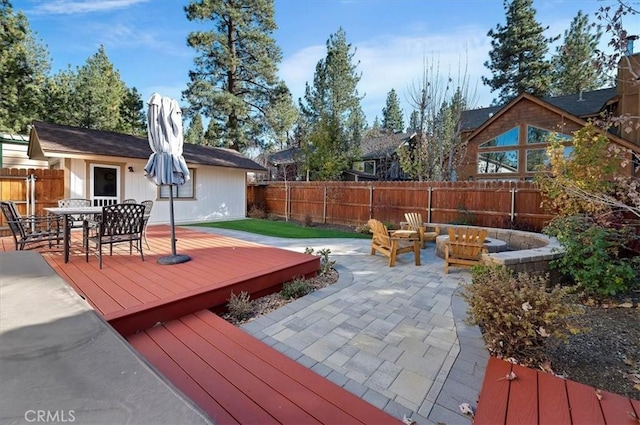 wooden deck featuring a fire pit and a patio area