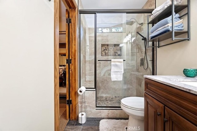 bathroom with tile patterned floors, vanity, toilet, and walk in shower