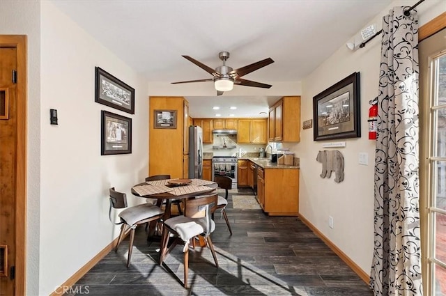 dining room with ceiling fan, sink, and dark wood-type flooring