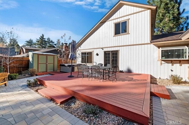 rear view of property featuring a shed and a wooden deck