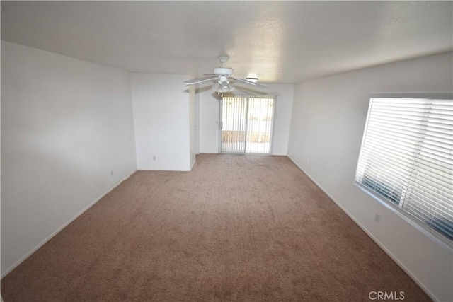 spare room featuring light carpet and ceiling fan