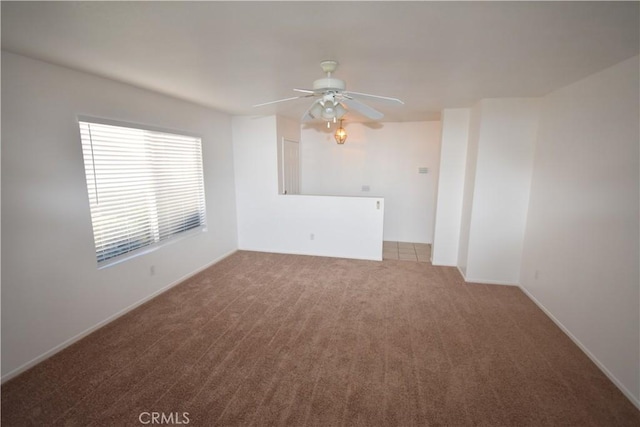 carpeted spare room with ceiling fan