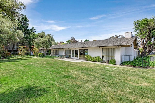 back of house with a lawn and a patio