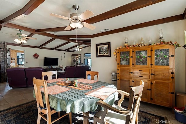 dining room with dark tile patterned flooring and vaulted ceiling with beams