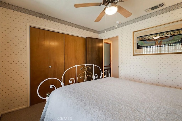 carpeted bedroom featuring ceiling fan and a closet