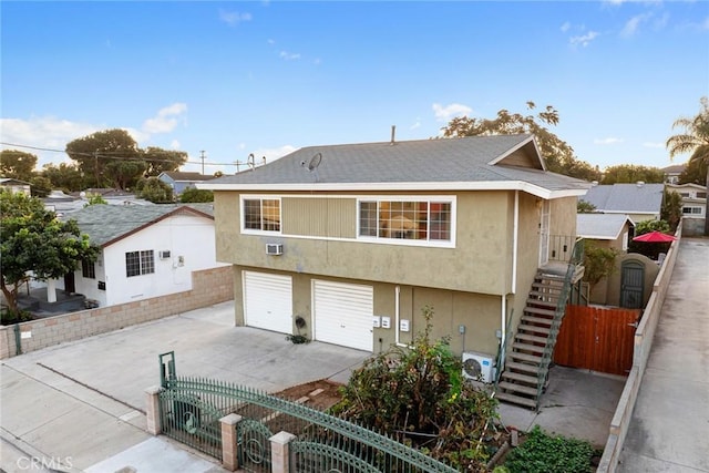 view of front of house featuring ac unit and a garage