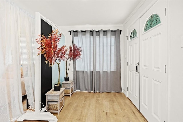 foyer entrance featuring light hardwood / wood-style flooring and crown molding