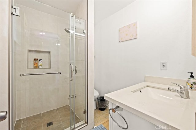 bathroom with tile patterned floors, vanity, toilet, and an enclosed shower