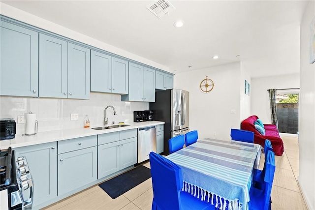 kitchen featuring light tile patterned flooring, sink, appliances with stainless steel finishes, and tasteful backsplash