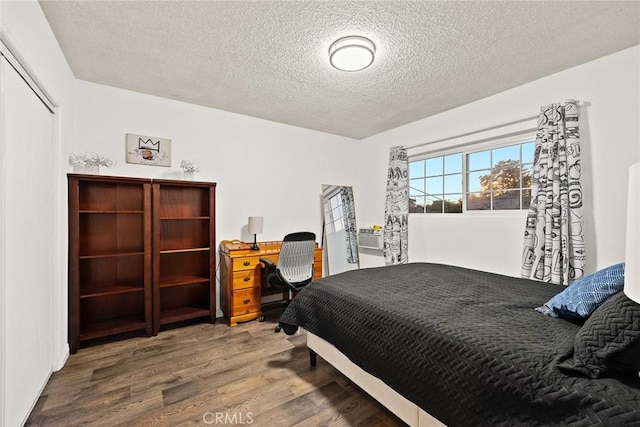 bedroom with a closet, a textured ceiling, and hardwood / wood-style flooring