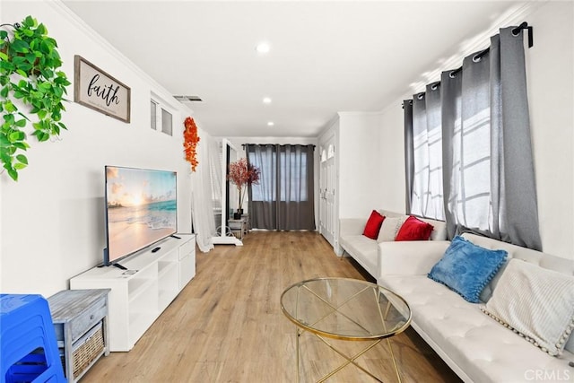 living room with light hardwood / wood-style flooring, a healthy amount of sunlight, and crown molding