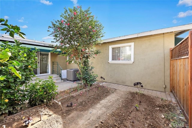 rear view of property with central AC unit and a patio