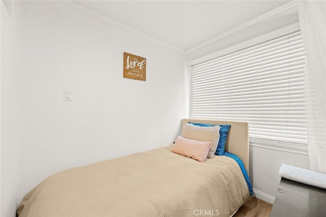 bedroom featuring wood-type flooring and crown molding