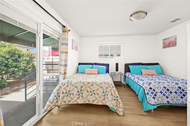 bedroom featuring access to exterior and wood-type flooring