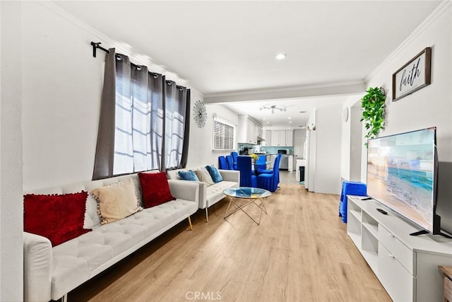 living room with light hardwood / wood-style flooring and crown molding