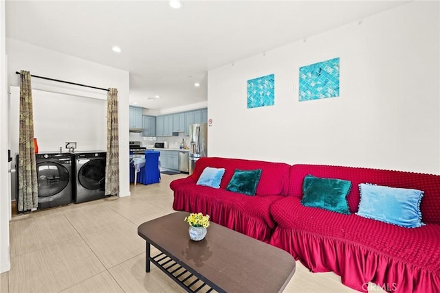 tiled living room featuring washer and clothes dryer