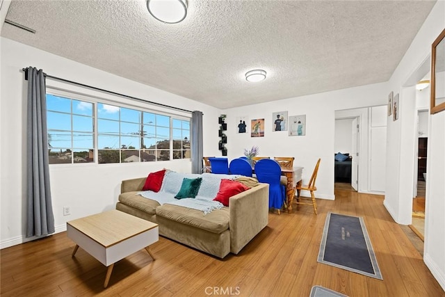 living room with light hardwood / wood-style flooring and a textured ceiling