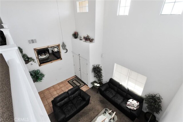 living room with tile patterned floors and a high ceiling