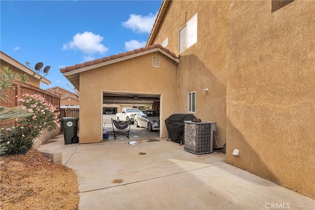 view of side of property featuring cooling unit and a garage