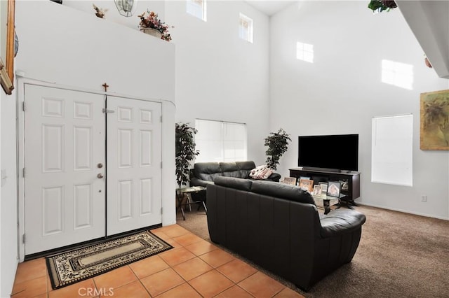 carpeted living room featuring a towering ceiling