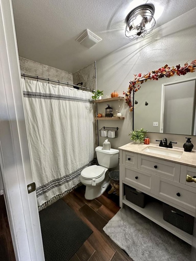 bathroom with vanity, hardwood / wood-style floors, a textured ceiling, and toilet