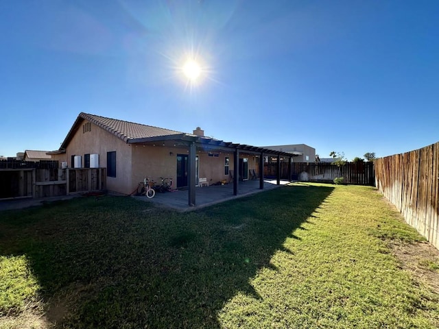 back of property featuring a patio area and a yard