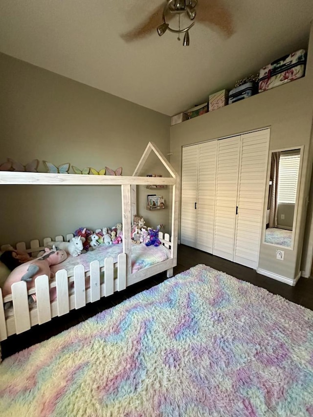 bedroom featuring ceiling fan, a closet, and dark wood-type flooring