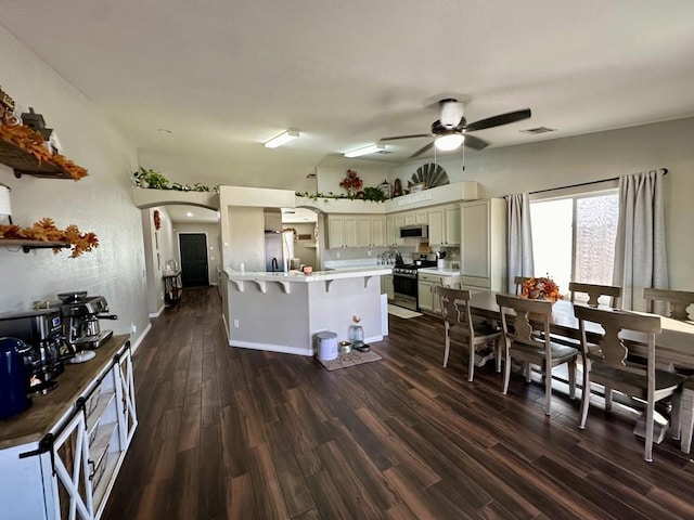 kitchen featuring stainless steel appliances, dark hardwood / wood-style floors, and ceiling fan