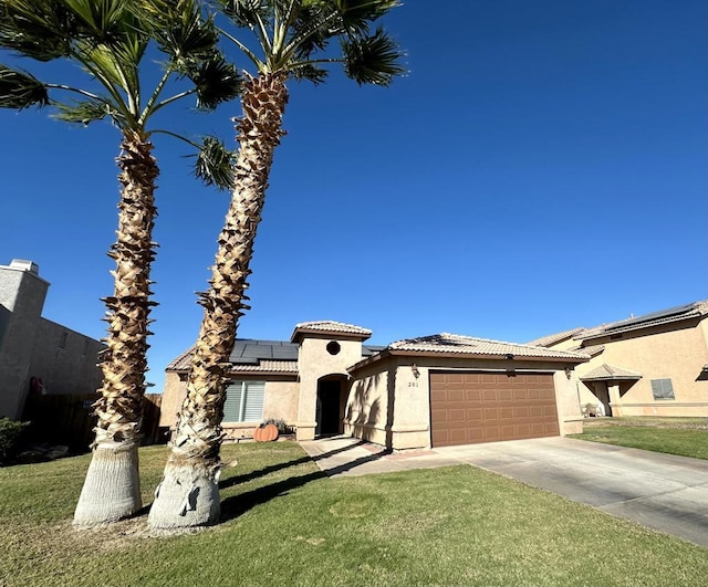 view of front of property with a garage, a front yard, and solar panels