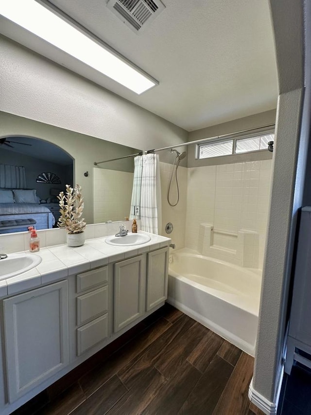 bathroom featuring ceiling fan, vanity, shower / tub combo, and hardwood / wood-style flooring