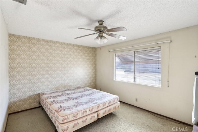 bedroom with a textured ceiling, light colored carpet, and ceiling fan