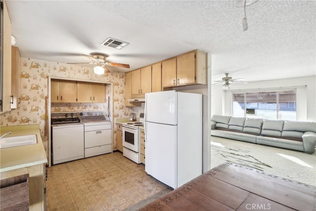 kitchen with sink, light brown cabinets, a textured ceiling, white appliances, and washer and clothes dryer