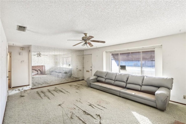 unfurnished living room with a textured ceiling, carpet floors, and ceiling fan