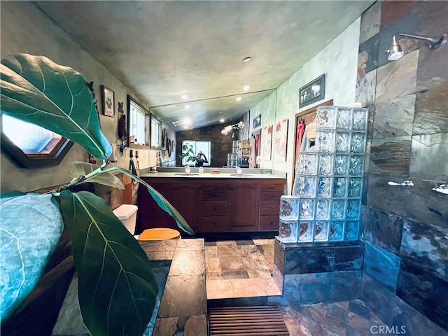 misc room featuring lofted ceiling, stone tile floors, and a sink