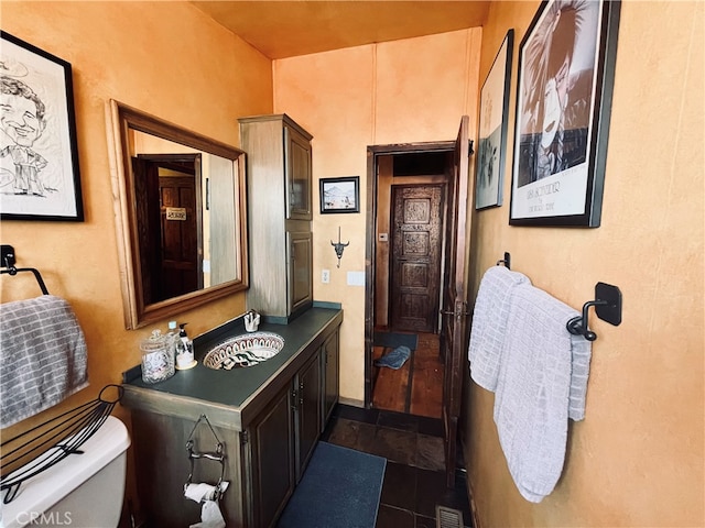 bathroom featuring toilet, tile patterned flooring, a sink, and visible vents