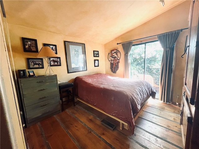 bedroom with vaulted ceiling and dark wood-type flooring