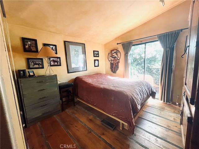 bedroom with vaulted ceiling, hardwood / wood-style flooring, and access to exterior