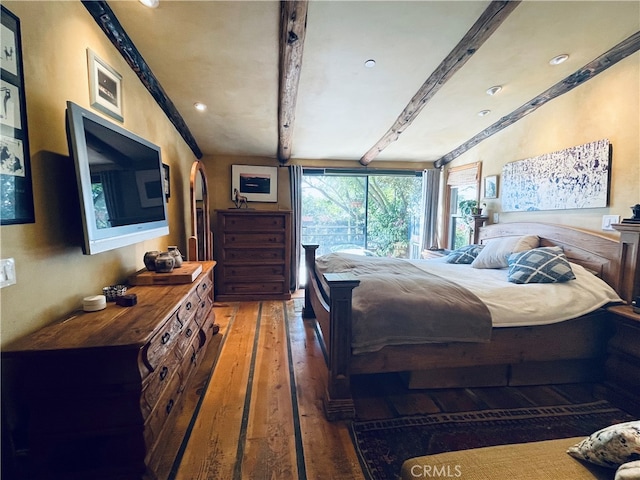 bedroom featuring beamed ceiling and dark hardwood / wood-style floors