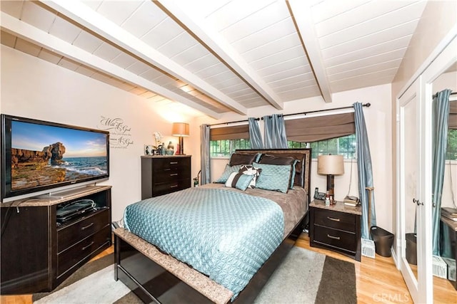 bedroom featuring multiple windows, beam ceiling, light hardwood / wood-style flooring, and wooden ceiling