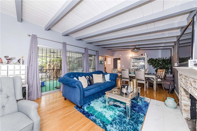 living room featuring hardwood / wood-style flooring, a fireplace, and beamed ceiling