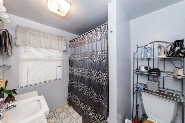 bathroom with sink, curtained shower, and toilet