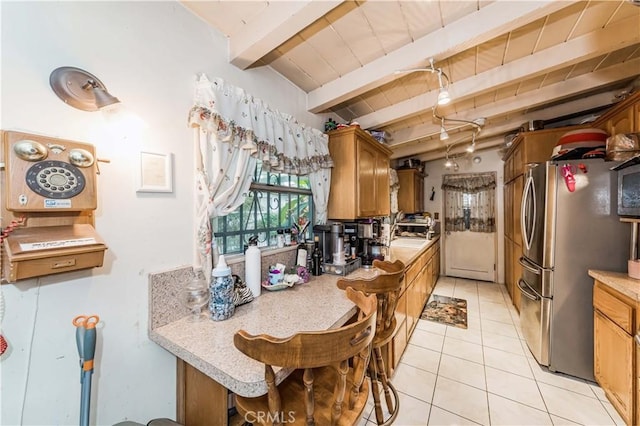 kitchen featuring light tile patterned flooring, wooden ceiling, beam ceiling, and stainless steel refrigerator