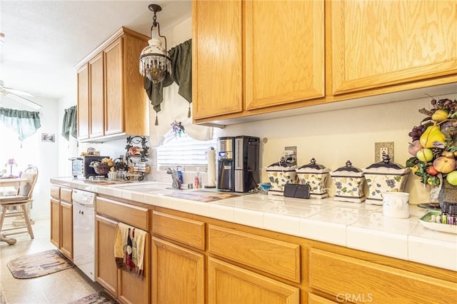 kitchen featuring tile countertops, white dishwasher, sink, ceiling fan, and light tile patterned floors