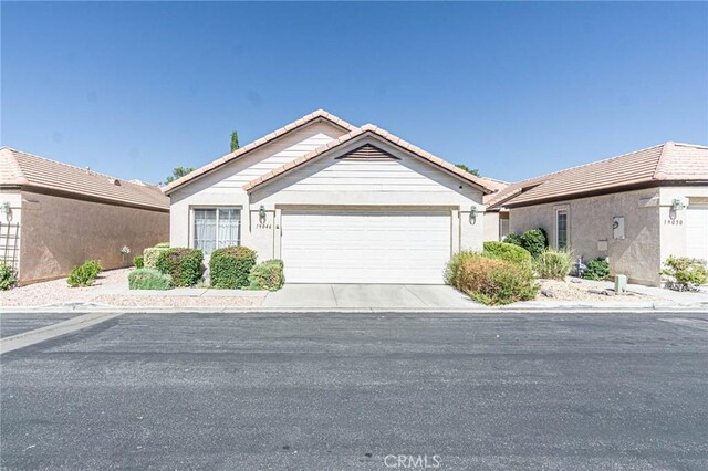 19046 Stoddard Way, Apple Valley, CA 92308 - ranch-style home with a tiled roof, a garage, and stucco siding