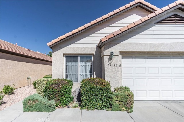 19046 Stoddard Way, Apple Valley, CA 92308 - entrance to property featuring a tile roof, a garage, and stucco siding