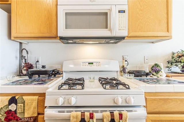 kitchen with tile counters and white appliances