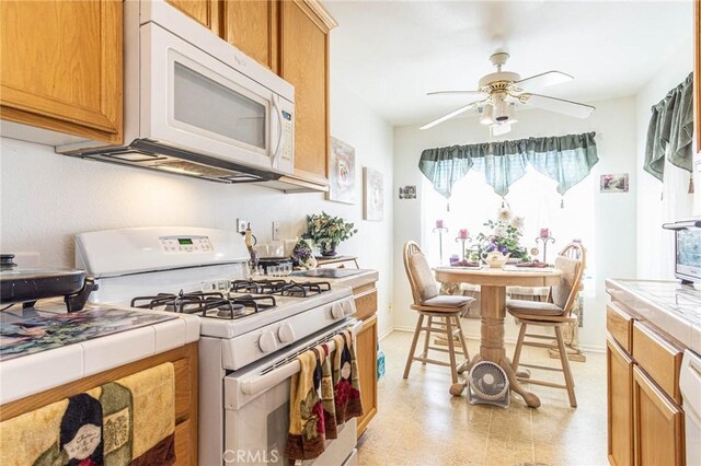 19046 Stoddard Way, Apple Valley, CA 92308 - kitchen with white appliances, tile counters, ceiling fan, and plenty of natural light
