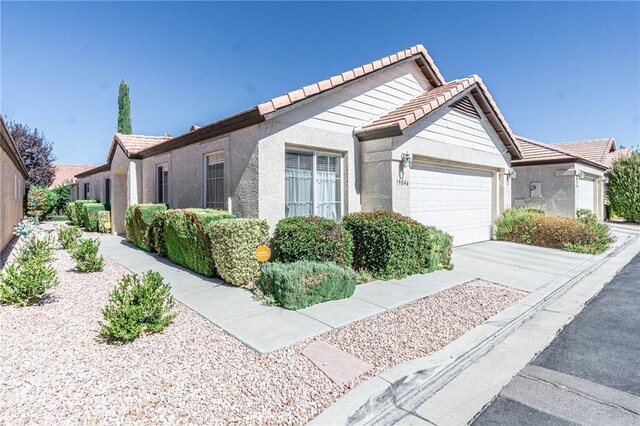 19046 Stoddard Way, Apple Valley, CA 92308 - view of front of property with an attached garage, a tile roof, concrete driveway, and stucco siding